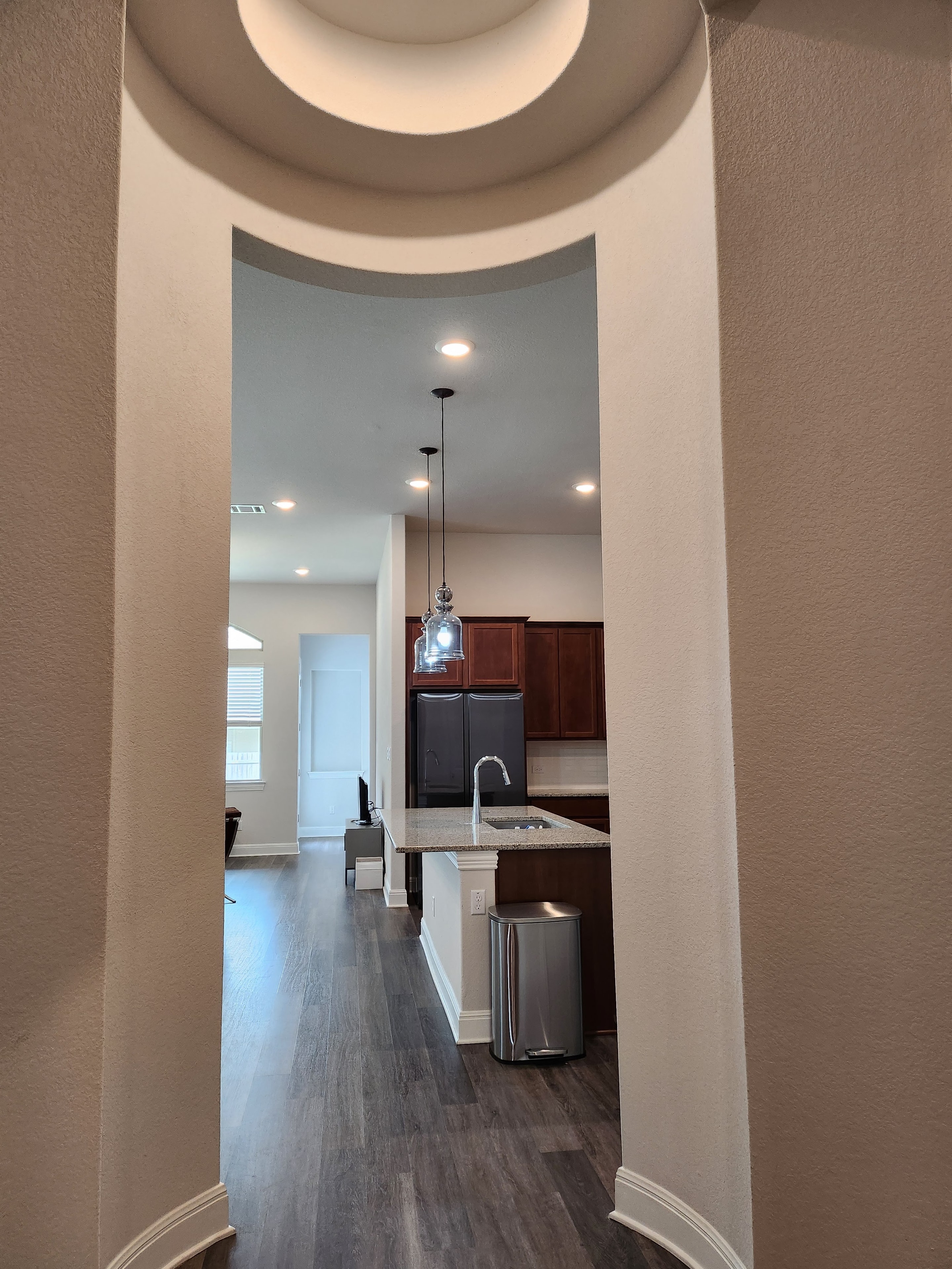 Hallway view into kitchen with arched ceiling